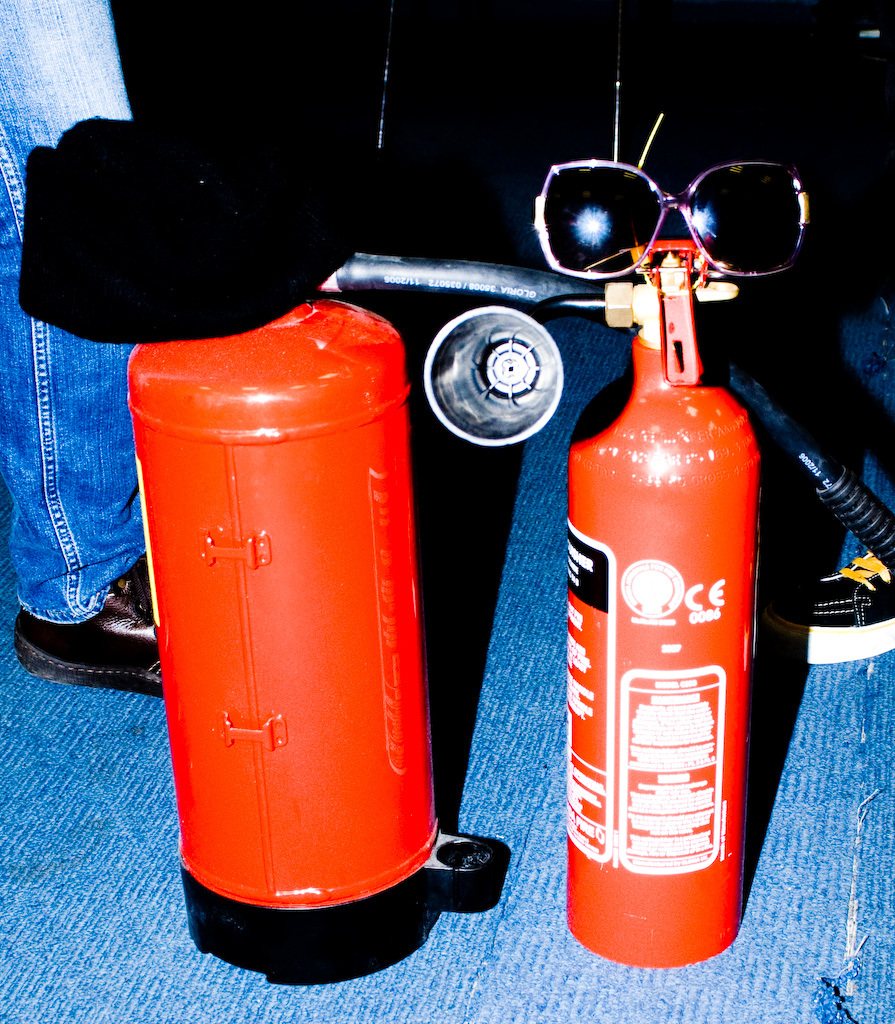 Two bright red fire extinguishers standing side by side